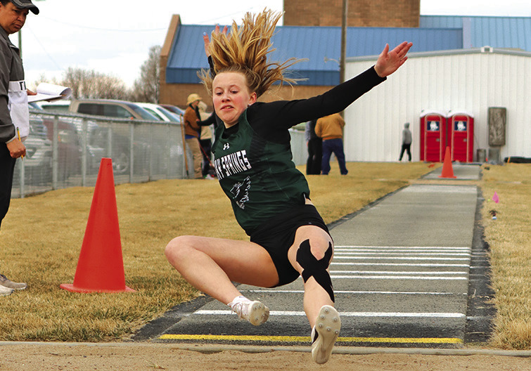 Photo by Scott Bidroski Freshman Reese Varvel slides into the landing pit during the Long Jump event in Bayard on March 28.